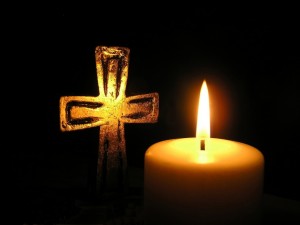 golden-cross-and-candle-in-dark-surroundings